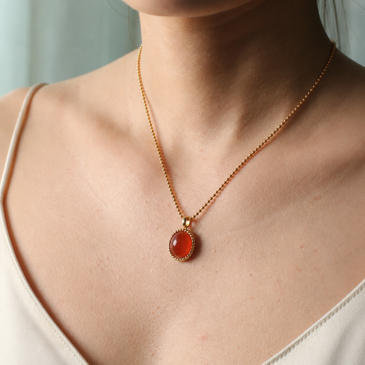 Twisted red agate pendant necklace in gold-tone setting